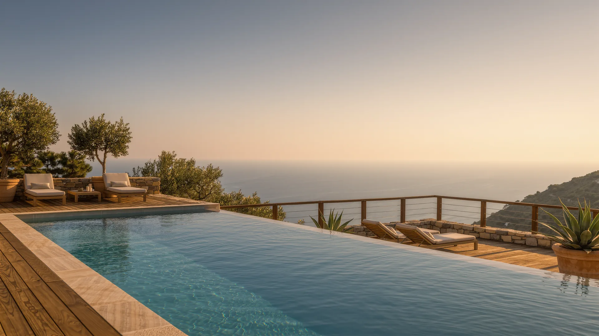 Terraza de villa moderna con piscina infinita sobre el Mediterráneo al anochecer