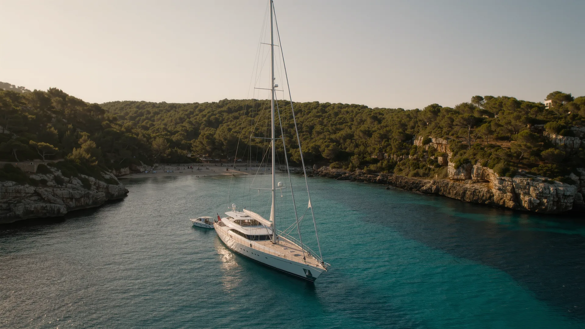 Velero fondeado en una cala turquesa de Mallorca al atardecer