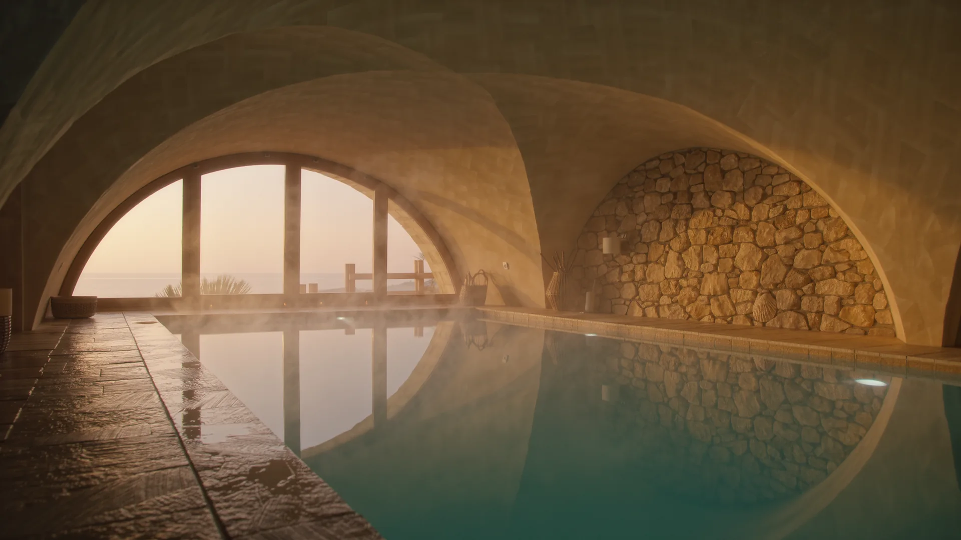 Piscina de spa iluminada desde el fondo en una sala abovedada de piedra