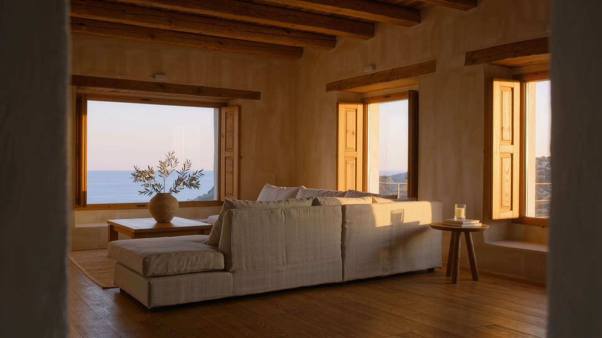 Salón mediterráneo con paredes de cal, sofá de lino y vigas de roble