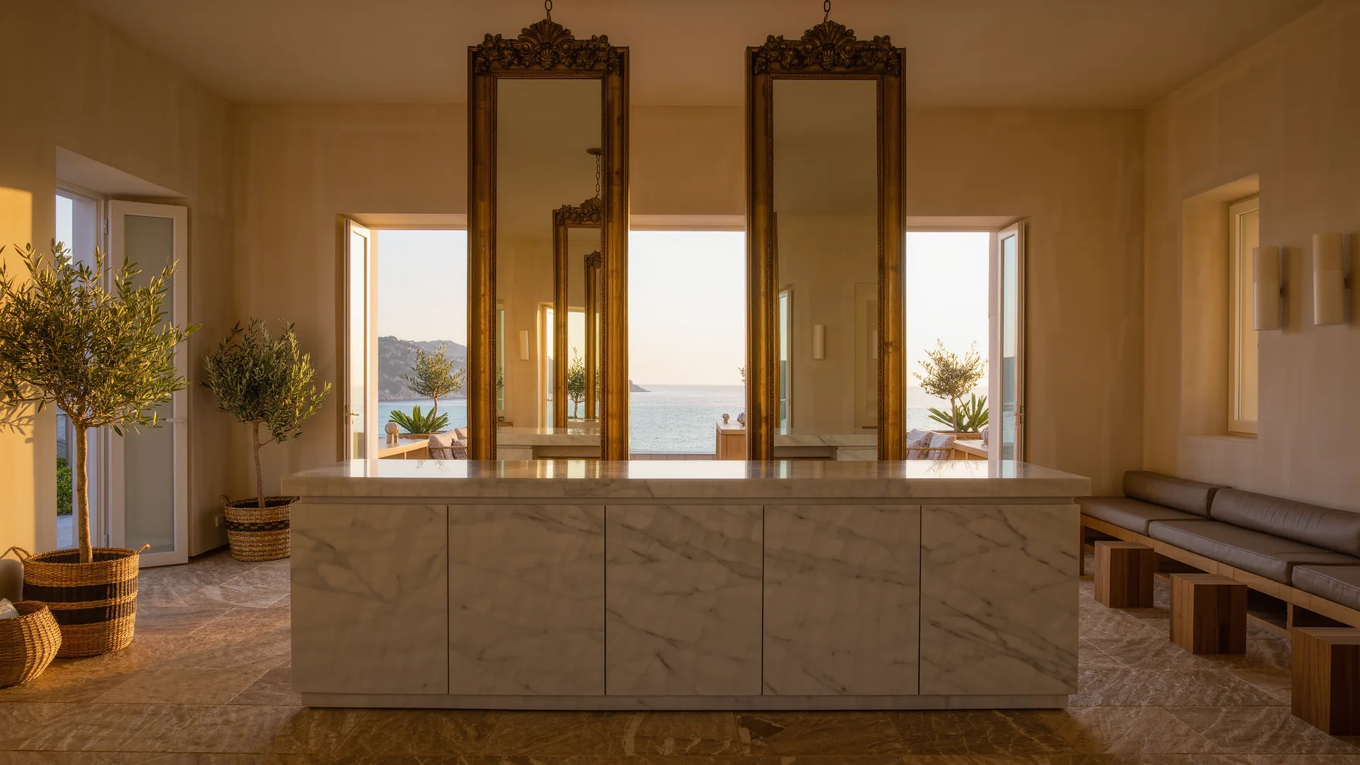 Interior elegante de peluquería con espejos de latón y encimera de mármol
