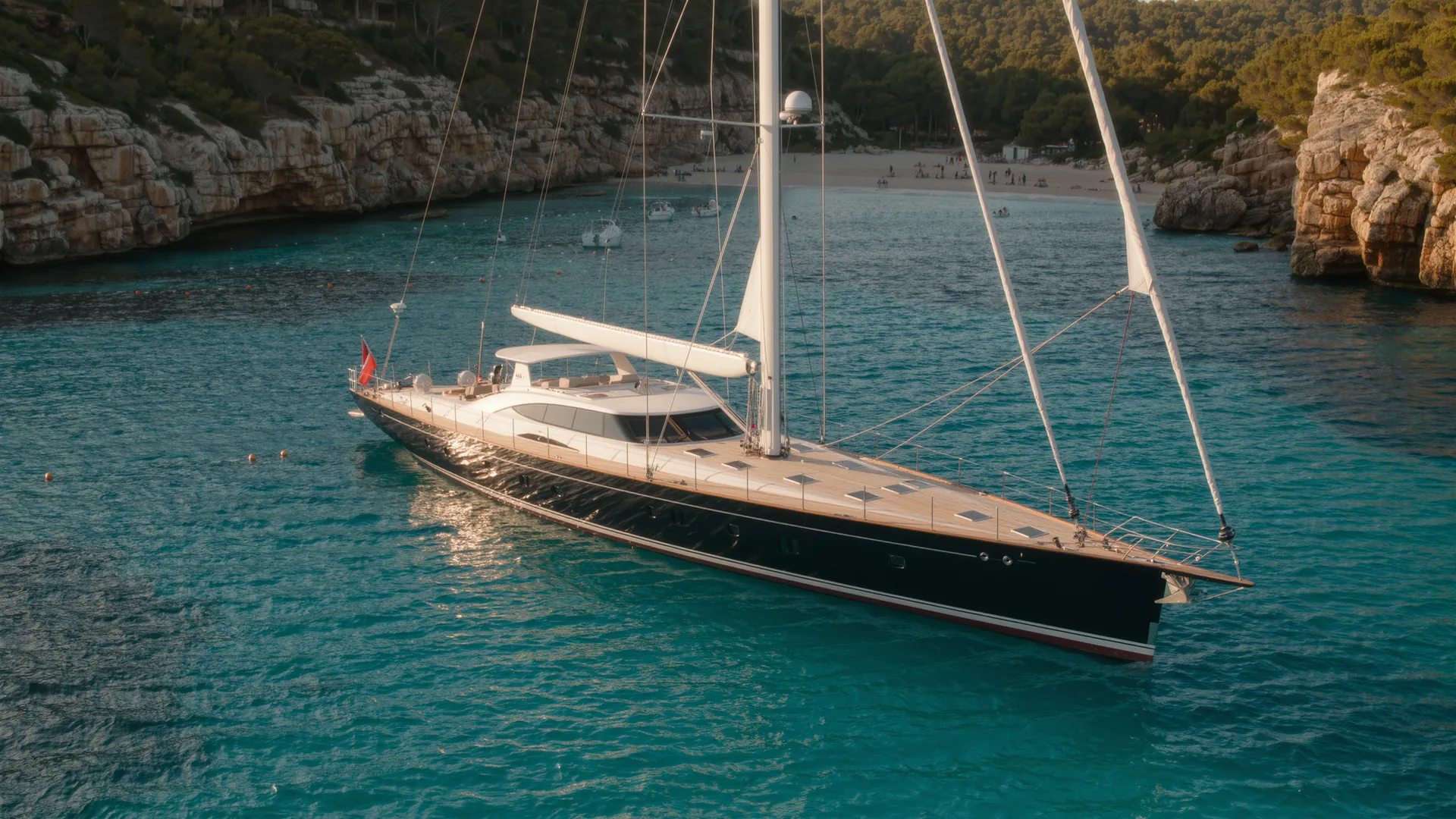 Velero fondeado en una cala turquesa de Mallorca al atardecer
