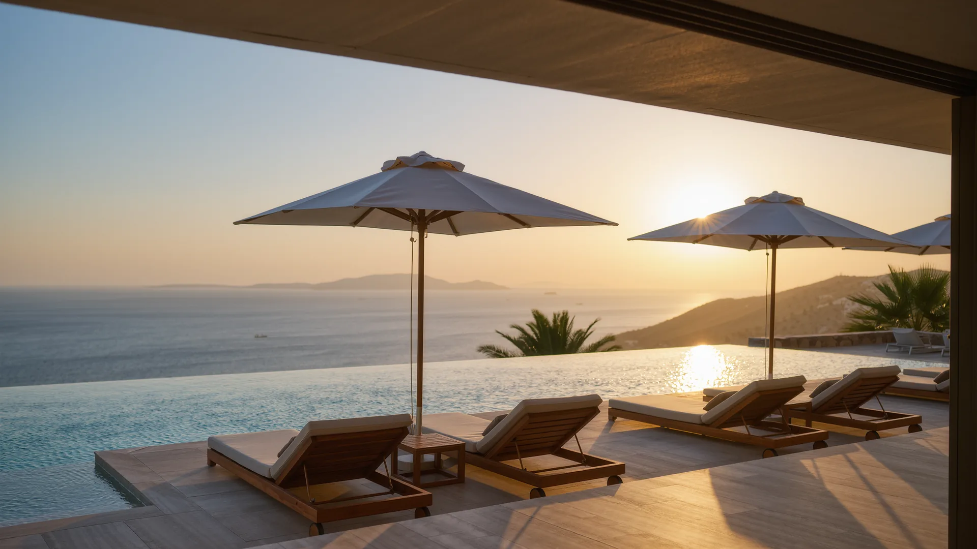 Terraza de piscina de resort con sombrillas frente al mar al atardecer